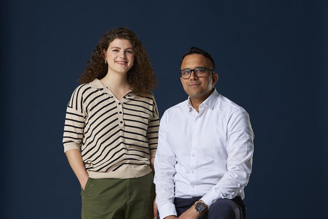Man sitting and woman standing on navy background