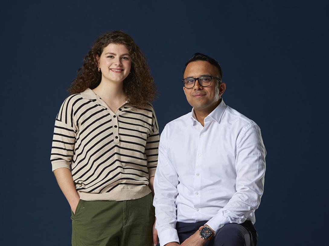 Man sitting and woman standing on navy background